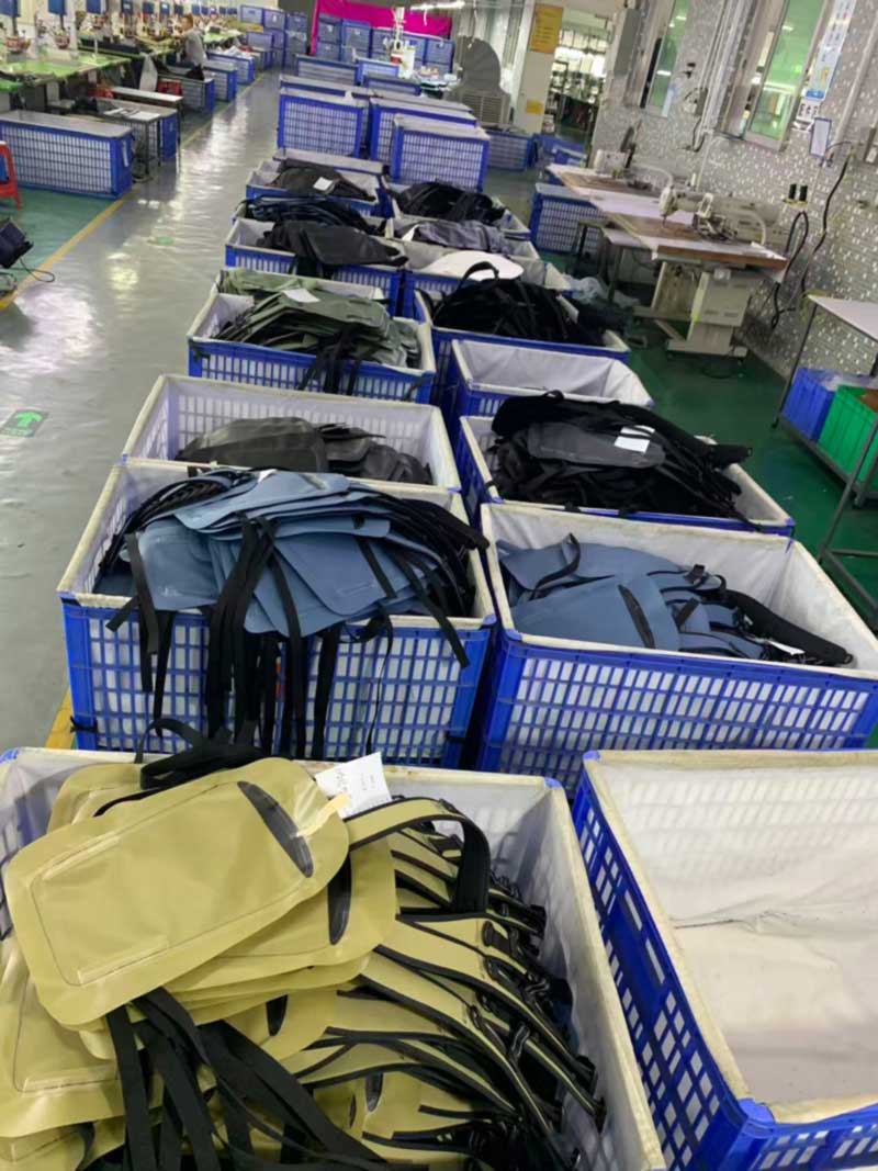 Rows of cloth-lined bins holding welded backpack panels in six different colourways